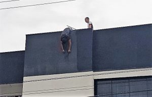 Homem fica pendurado em prédio após sofrer descarga elétrica